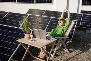 Frau sitzt in mitten von Photovoltaik